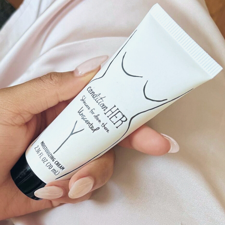 Close-upof-woman-in-beige-slip-holding-a-tube-of-conditionHER-with-matching-almond-shaped-nails